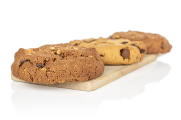 Group of three whole sweet brown cookie on wooden cutting board isolated on white background