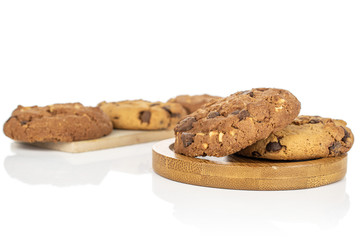 Group of five whole sweet brown cookie on wooden cutting board on round bamboo coaster isolated on white background