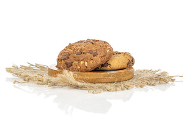 Group of two whole sweet brown cookie on round bamboo coaster with jute fabric isolated on white background