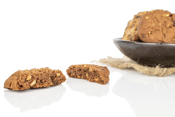 Group of two whole two halves of sweet brown cookie in glazed bowl with jute fabric isolated on white background