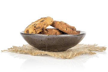 Group of three whole sweet brown cookie in glazed bowl with jute fabric isolated on white background