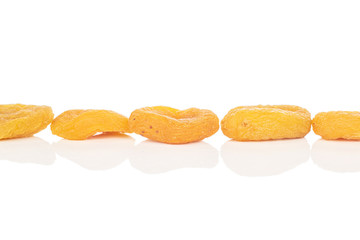 Group of five whole dried orange apricot in line isolated on white background