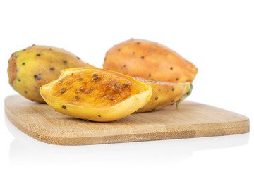 Group of two whole two halves of prickly green opuntia on bamboo cutting board isolated on white background