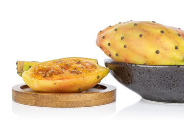 Group of one whole two halves of prickly green opuntia on round bamboo coaster in glazed bowl isolated on white background