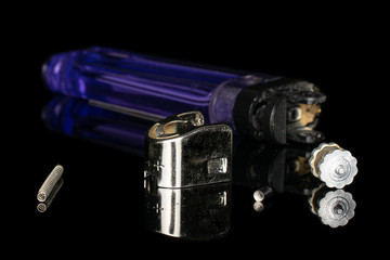 Group of one whole four pieces of plastic lighter isolated on black glass