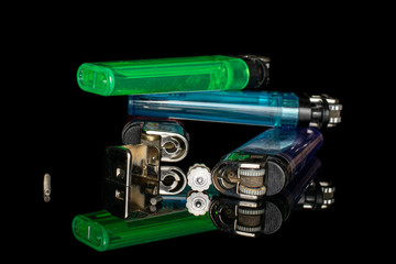 Group of four whole four pieces of plastic lighter isolated on black glass