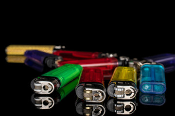 Lot of whole plastic lighter isolated on black glass