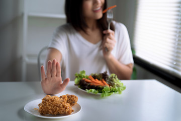 Dieting and good health concept, the young lady refused fried food and chose healthy food.