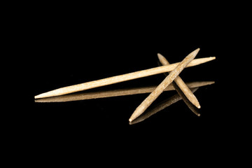 Group of three whole wooden brown toothpick isolated on black glass