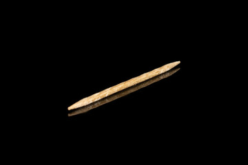 One whole wooden brown toothpick isolated on black glass