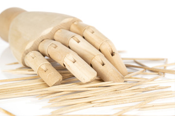 Lot of whole wooden brown toothpick with wooden hand isolated on white background