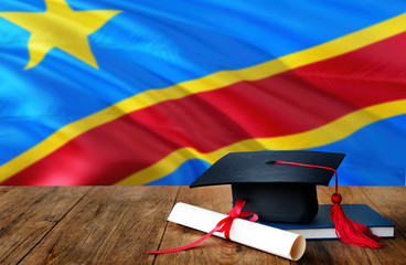 Congo education concept. Graduation cap and diploma on wooden table, national flag background....