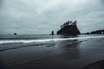 The famous La Push second beach: views of logs of driftwood and rocks in the sea. Gloomy weather.