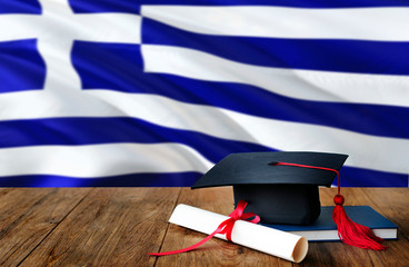 Greece education concept. Graduation cap and diploma on wooden table, national flag background....