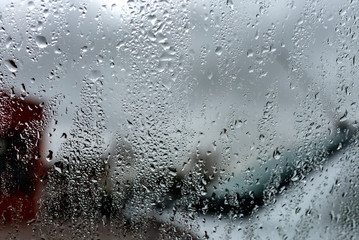 Rain drops on a window against cloudy sky. city in rainy season