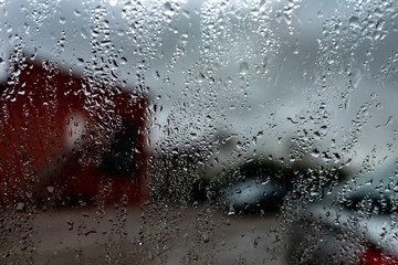 Rain drops on a window against cloudy sky. city in rainy season