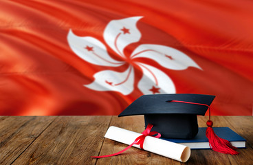 Hong Kong education concept. Graduation cap and diploma on wooden table, national flag background....