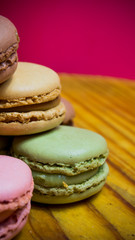 Colored macarons isolated on wooden dish, typical French dish