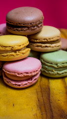 Colored macarons isolated on wooden dish, typical French dish