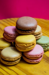 Colored macarons isolated on wooden dish, typical French dish