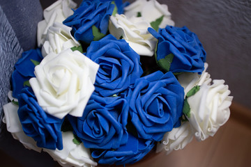 A bouquet of white and blue artificial roses on the floor