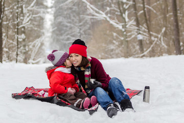 Fototapeta na wymiar Mother and daughter having fun at winter time.