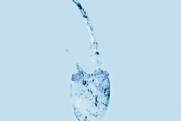 Pour water onto a glass of water with splash isolated on white background