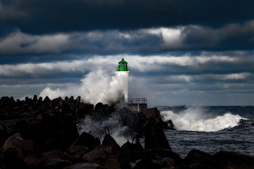 Fototapeta na wymiar Brekwater and lighthouse in storm, Ventspils, Latvia.