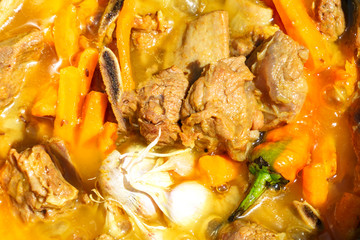 Step three of Cooking tasty pilaf - Zirvak. Fried beef ribs with vegetables and spice, add garlic and chili, close up