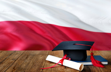 Poland education concept. Graduation cap and diploma on wooden table, national flag background....