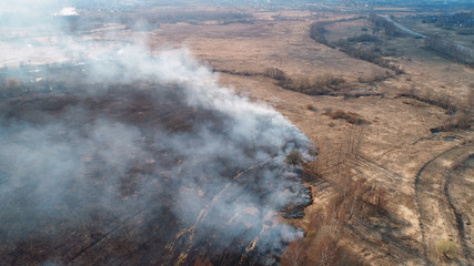 Forest and field fire. Dry grass burns, natural disaster. Aerial view.