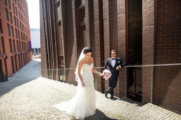Bride and groom walking in the city, wedding day, marriage concept. Bride and groom in urban...