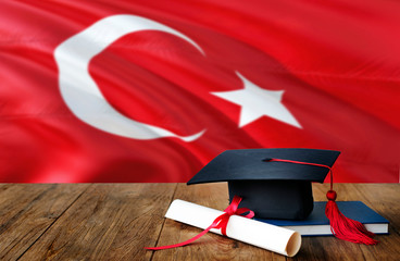 Turkey education concept. Graduation cap and diploma on wooden table, national flag background. Succesful student.