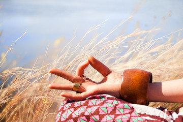 closeup of woman hand in mudra gesture practice yoga meditation outdoor in grass summer day