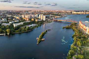 Big city aerial shot. Long and wide streets filled with cars. Shooting in the evening with the setting sun.