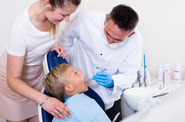Female with son are visiting dentist