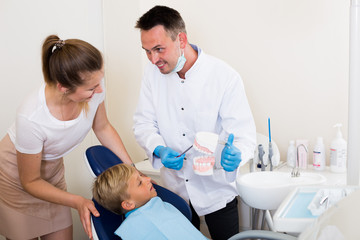 Fototapeta premium Professional in uniform is telling to young boy and mother about hygiene