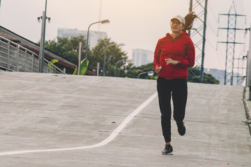 Obraz premium Young women runner on the street be running for exercise on city road; sport, people, exercising and lifestyle concept