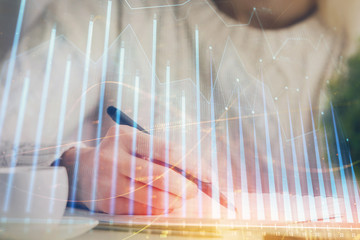 Forex chart displayed on woman's hand taking notes background. Concept of research. Multi exposure