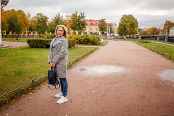 Fototapeta premium Portrait of a young woman walking in the autumn on the streets of St. Petersburg