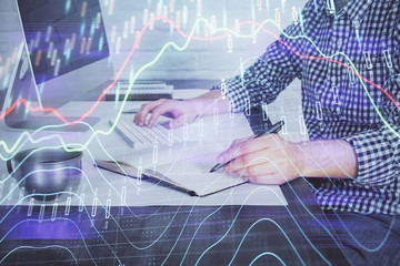 Naklejka premium Double exposure of stock market chart with man working on computer on background. Concept of financial analysis.