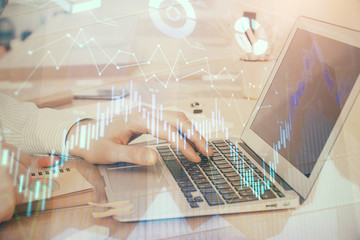 Double exposure of stock market graph with man working on laptop on background. Concept of financial analysis.
