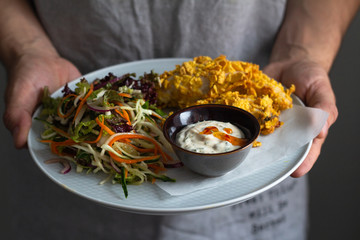 chicken nuggets and vegetable salad in male hands