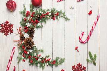 Fototapeta na wymiar Christmas wreath on white wooden backdrop