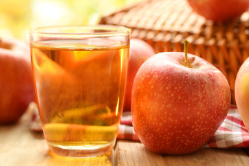 Apple juice pure in glass with ripe fruits