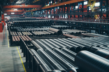 heavy industry concept, construction machinery - long metal pipes inside a large room. Building materials in the hangar