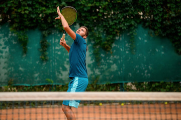 Tennis player getting ready to hit a ball and looking up