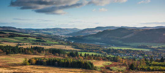 Panoramic view of Pitlochry in Perthshire, Scotland - heather covered hills, meandering river, mountains