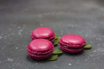 Colorful french macarons cookies (macaroons) on a dark background. Dessert for served with tea or coffee break. Holiday gift for women.