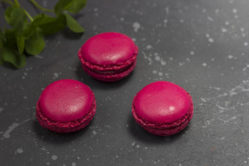 Colorful french macarons cookies (macaroons) on a dark background with copy space. Dessert for served with tea or coffee break.